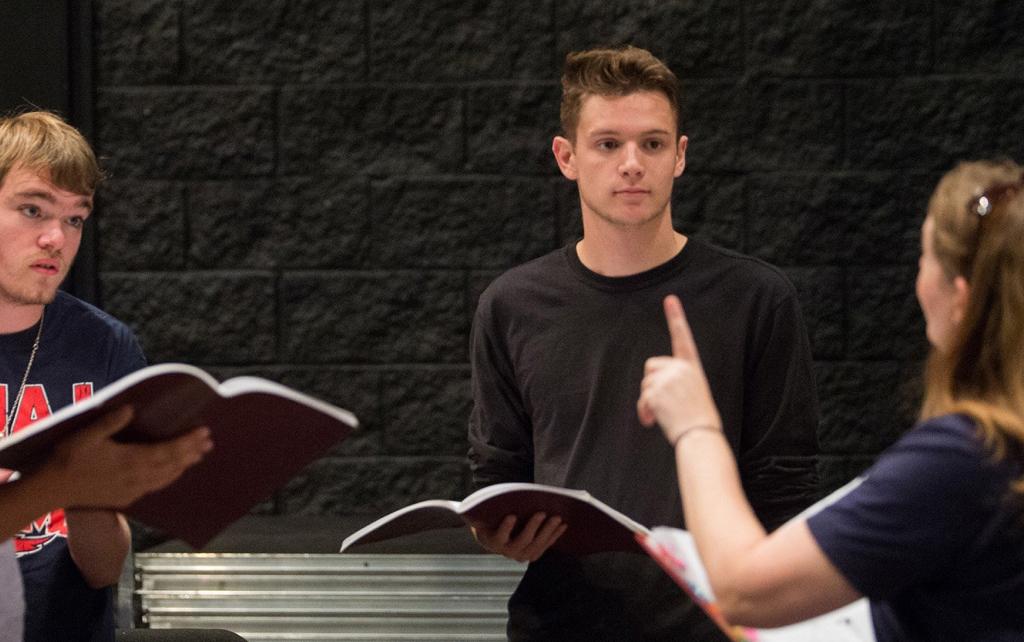 Theatre teacher and students reading scripts